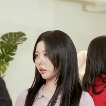 a woman with long black hair wearing a pink sweater