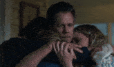 a man with a bandage on his arm is hugging two children