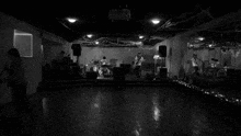 a black and white photo of a band playing instruments in a dark room