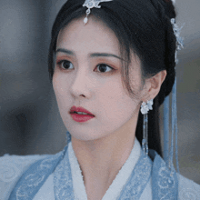 a close up of a woman 's face wearing a blue and white outfit