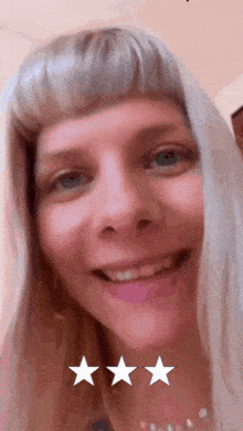 a close up of a woman 's face with three stars on the bottom
