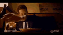 a person is cutting a piece of food on a plate that says showtime on it