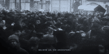 a black and white photo of a crowd of people with the words believe us on ancestors