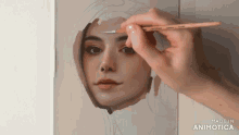 a person is painting a woman 's face with a brush and the words made in animotica on the bottom