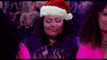 a woman is wearing a santa hat on her head