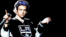 a man in a la jersey is holding a microphone