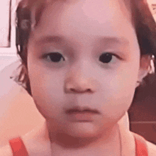 a little girl is making a funny face with her mouth open .