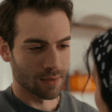 a man with a beard looks at a woman