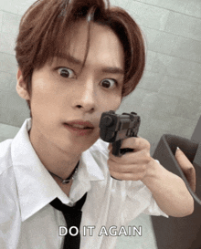 a man in a white shirt and tie is pointing a gun at the camera with the words do it again above him