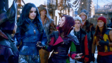 a group of people are standing next to each other and one of them is holding another woman 's hand .