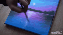 a person is painting a sunset on a canvas with the words made in animotica on the bottom