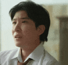 a man in a white shirt and tie is making a sad face