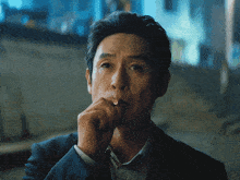 a man in a suit is smoking a cigarette