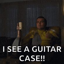 a man is sitting in a chair and pointing at something with the words " i see a guitar case " below him