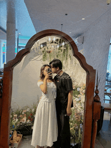 a couple taking a picture in front of a mirror that says love