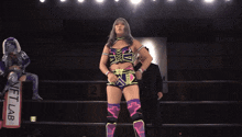 a female wrestler stands in front of a sign that says netfab on it