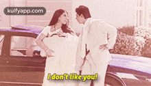a man and a woman are standing in front of a car and the woman says i don 't like you