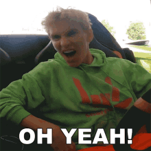 a young man in a green hoodie is sitting in a car with the words oh yeah written below him