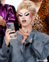 a drag queen is taking a picture of herself with her cell phone