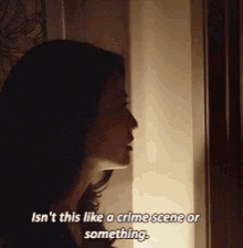 a woman is standing in front of a window and saying `` isn t this like a crime scene or something . ''