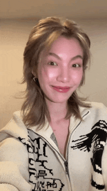 a woman wearing a sweater with a tiger on it is smiling