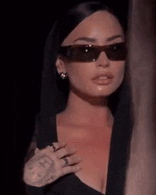 a close up of a woman wearing sunglasses and a black top .