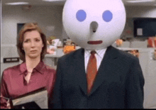 a man with a jack in the box head is standing next to a woman