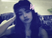 a woman wearing a hat has a butterfly on her head