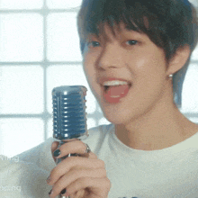 a close up of a person holding a microphone with the word dancing in the background