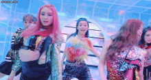 a group of girls are dancing on a stage in a room .