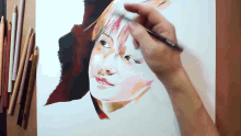 a person is painting a picture of a woman 's face