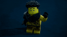 a yellow lego character with black hair and a black scarf around his neck