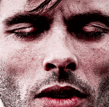 a close up of a man 's face with his eyes closed and red lips