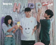 a group of people standing in front of balloons with the word happ written on them
