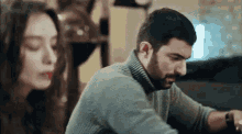 a man and a woman are sitting next to each other .