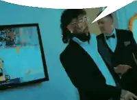 a man in a tuxedo stands in front of a tv