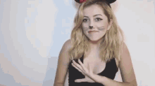 a woman wearing a mouse costume is making a face with her hands .