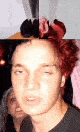 a man with red hair is making a funny face with a woman behind him