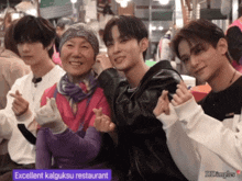 a group of people posing for a picture with a sign that says excellent kalgukse restaurant on it