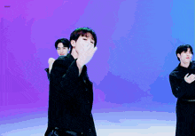 a man in a black suit is dancing in front of a purple background with the word dash below him