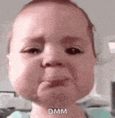 a baby is crying with tears coming out of his eyes and making a funny face .