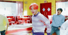 a man with red hair is dancing in a diner with other people