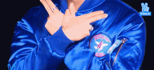a person wearing a blue jacket is making a peace sign with their hands