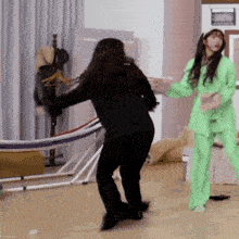 two women are standing next to each other in a room .