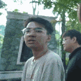 a young man wearing glasses and a t-shirt that says " ice "