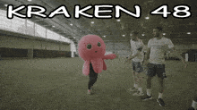 a group of soccer players are standing around a pink octopus mascot that says kraken 48 on the top