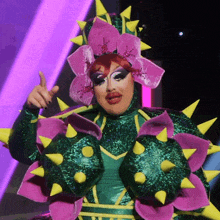 a drag queen is wearing a flower costume with spikes