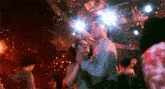 a man and a woman are dancing together in a disco club .