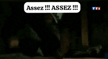 a person is sitting in a dark room with a speech bubble that says assez !!! assez !!!