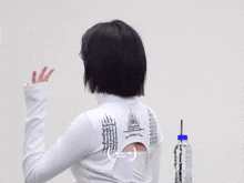 a woman wearing a white turtleneck with black writing on it